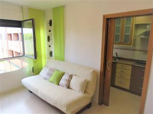 a living room with a white couch and a kitchen at ISLA LUNA. (familias/parejas) in Isla