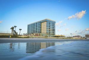 - un bâtiment sur la plage à côté de l'eau dans l'établissement Ocean Side Inn Studios, à Daytona Beach