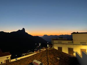 uma vista para o pôr-do-sol a partir dos telhados dos edifícios em Casa El Mirador del Almendro em Tejeda
