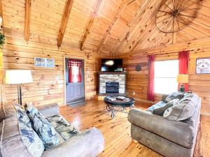 ein Wohnzimmer mit Sofas und einem Kamin in einer Hütte in der Unterkunft J Willy's Refuge cabin in Townsend