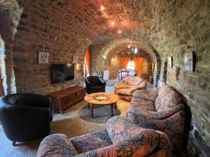 a living room with couches and a table in a cave at La Abadia in Coscojuela de Sobrarbe