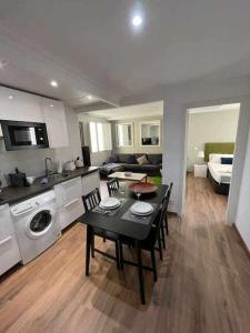 a kitchen and living room with a table and a dining room at Apartamento IV AlcaláRetiro Ideal Parejas in Madrid