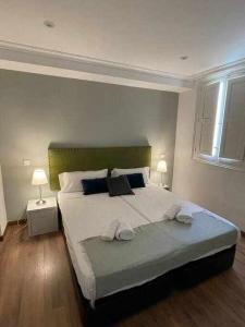 a bedroom with a large bed with two towels on it at Apartamento IV AlcaláRetiro Ideal Parejas in Madrid