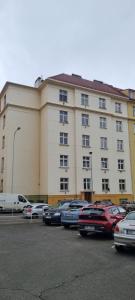 een groot gebouw met auto's geparkeerd op een parkeerplaats bij Folimanka apartment in Praag