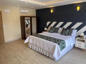 a bedroom with a large bed with a black wall at Pousada Granja Santa Barbara in Petrópolis