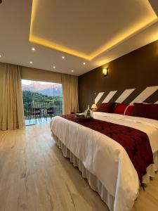 a hotel room with a large bed and a balcony at Pousada Granja Santa Barbara in Petrópolis