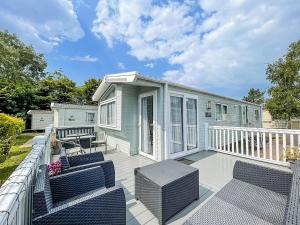 a tiny house with a deck with chairs and a porch at Beautiful 6 Berth Caravan At Southview Holiday Park In Skegness Ref 33031s in Skegness