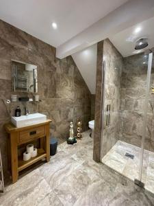 y baño con lavabo y ducha. en Acorn Cottage, en Ross-on-Wye