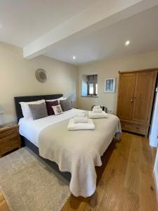 1 dormitorio con 1 cama grande y toallas. en Acorn Cottage, en Ross-on-Wye