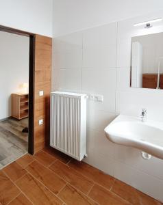 baño con radiador blanco y lavabo en Penzion U Provazníka en Zdíkov
