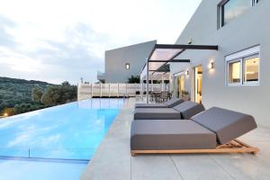 Agia Triada的住宿－Moly - Luxury Villa with Heated Private Pool，一座带游泳池和房子的别墅