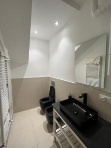 baño con lavabo negro y aseo en Loft Corte d'Appello - Host by Traveller's Nest, en Turín