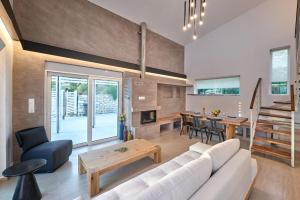 uma sala de estar com um sofá branco e uma mesa em Moly - Luxury Villa with Heated Private Pool em Agia Triada