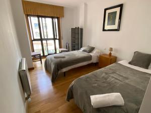 奧波里尼奧的住宿－RAIOLA，一间卧室设有两张床和窗户。