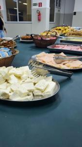 una mesa cubierta con placas de queso y otros alimentos en Hotel Beirut, en Aparecida