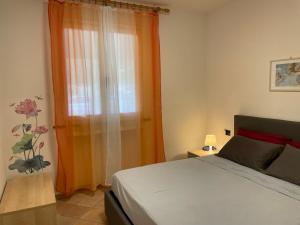 a bedroom with a bed and an orange curtain at Mare e natura a Nisportino in Casa Castagno