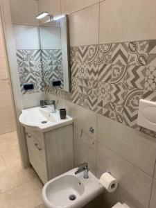 a bathroom with a sink and a toilet and a mirror at B&B Giusy in Sava +20 photos