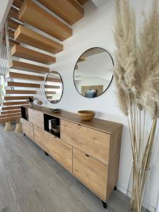 ein Badezimmer mit einer Holzkommode und 2 Spiegeln in der Unterkunft Hillside house- Modern, upscale home w/SEA VIEWS in Estepona