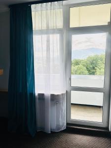 a room with a window with a blue curtain at Ondraszek in Ustroń