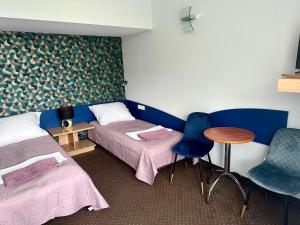 a room with two beds and a table and chairs at Ondraszek in Ustroń