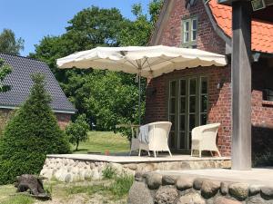 a patio with two chairs and an umbrella at Gästehaus Weidenkörbchen in Jork