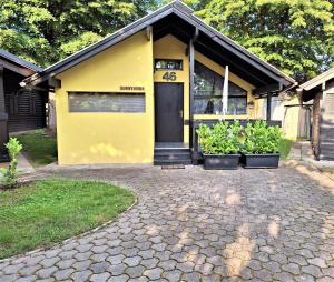 Una casa amarilla con plantas delante. en Sunny Home, en Čatež ob Savi