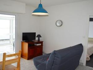 a living room with a blue couch and a tv at Appartement Trégastel: Vue mer, Parking privé, Petit chien admis. - FR-1-542-5 in Trégastel