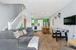 a living room with a couch and a dining room at Modern Eco House With Parking in Brighton & Hove