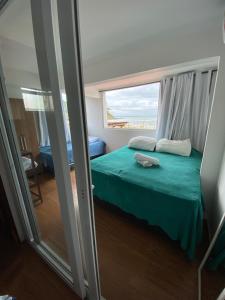 Casa de Praia في مورو دي ساو باولو: غرفة نوم بسرير اخضر ونافذة