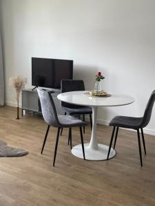 a white table and chairs in a living room at Apartament Tęczowa in Gdynia