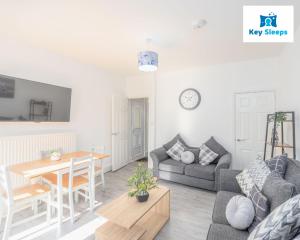 a living room with a couch and a table at Key Sleeps - Spacious & Modern Contractor House & City Centre - Lincolnshire in Lincolnshire