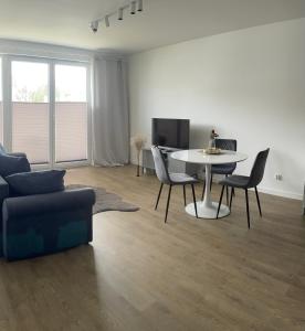 a living room with a couch and a table and chairs at Apartament Tęczowa in Gdynia