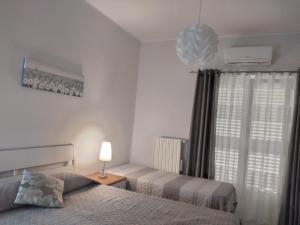 a bedroom with two beds and a lamp and a window at Casa di Tina in Castellana Grotte