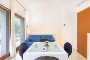 ein Wohnzimmer mit einem Tisch, Stühlen und einem blauen Sofa in der Unterkunft Sa Perda 21 - FREE WIFI - 500mt from the beach in Costa Rei