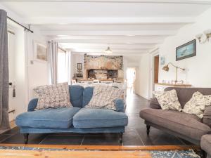 un sofá azul y una silla en la sala de estar en Rockhopper Cottage en Penzance