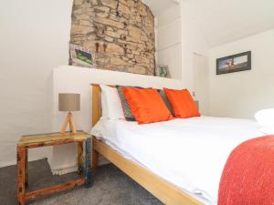 1 dormitorio con 1 cama y 1 mesa en Rockhopper Cottage en Penzance