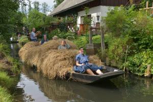 a group of people on a hay bale boat in a river at Ferienwohnung Nachtigall in Burg