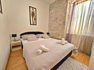 1 dormitorio con 2 camas y pared de piedra en Apartments Moni, en Split