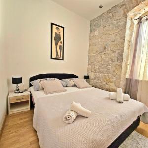 2 camas en un dormitorio con pared de piedra en Apartments Moni, en Split