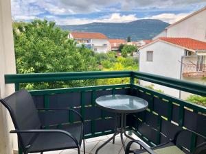 a table and chairs on a balcony with a view at Krišto Croatia in Kaštela
