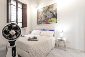 una camera con letto bianco e ventilatore di Appartamento Andrea Amati nel Cuore di Cremona a Cremona