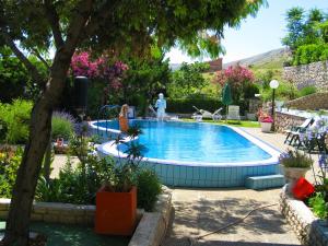 una piscina en un jardín con una persona a su lado en Family Apartments K&M, en Pag