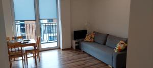 ein Wohnzimmer mit einem Sofa und einem Tisch sowie ein Esszimmer in der Unterkunft Apartamenty Niko in Zator