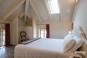 a bedroom with a large white bed and windows at Residence Ortensia in Baveno