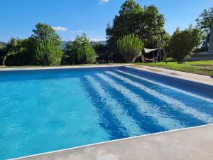 een zwembad met blauw water in een tuin bij Quinta Paúl de Baixo in Guimarães