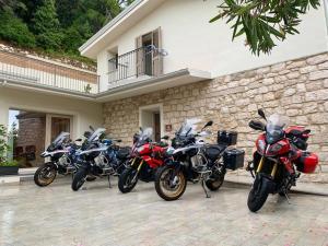 a row of motorcycles parked in front of a building at Tarsis Guest House in Baunei
