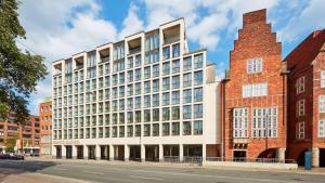 a large white building with windows on a street at ATLANTIC Grand Hotel Bremen in Bremen