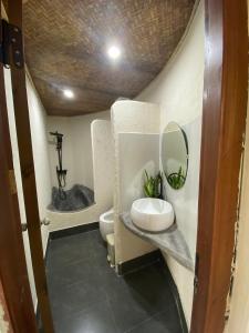 bagno con servizi igienici, lavandino e specchio di V Village Làng quê Việt 