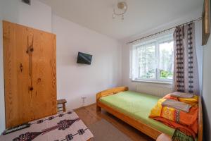 Un dormitorio pequeño con una cama y una ventana. en Willa Skorusa, en Zakopane