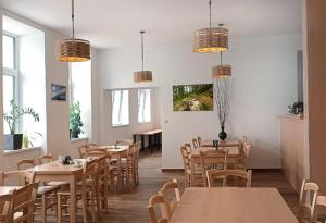 a restaurant with wooden tables and chairs and windows at Penzion U Provazníka in Zdíkov